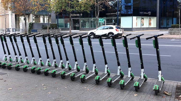 A row of e-scooters on a city street