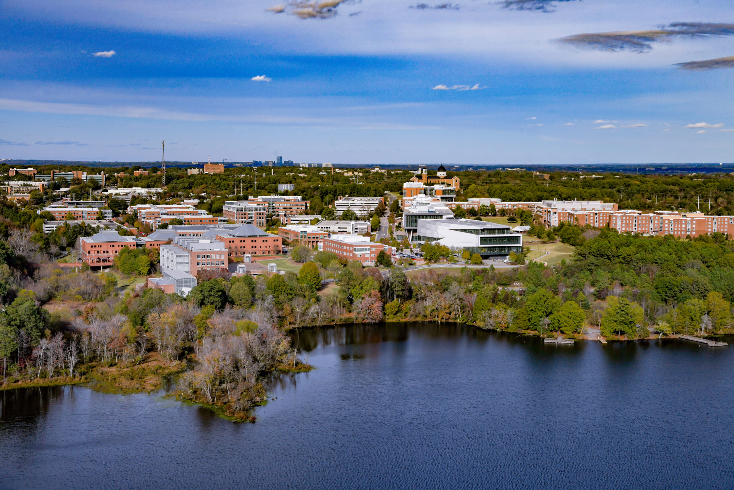 Aerial view of Centennial Campus showcasing Lake Raleigh, Wilson College of Textile and Hunt library.